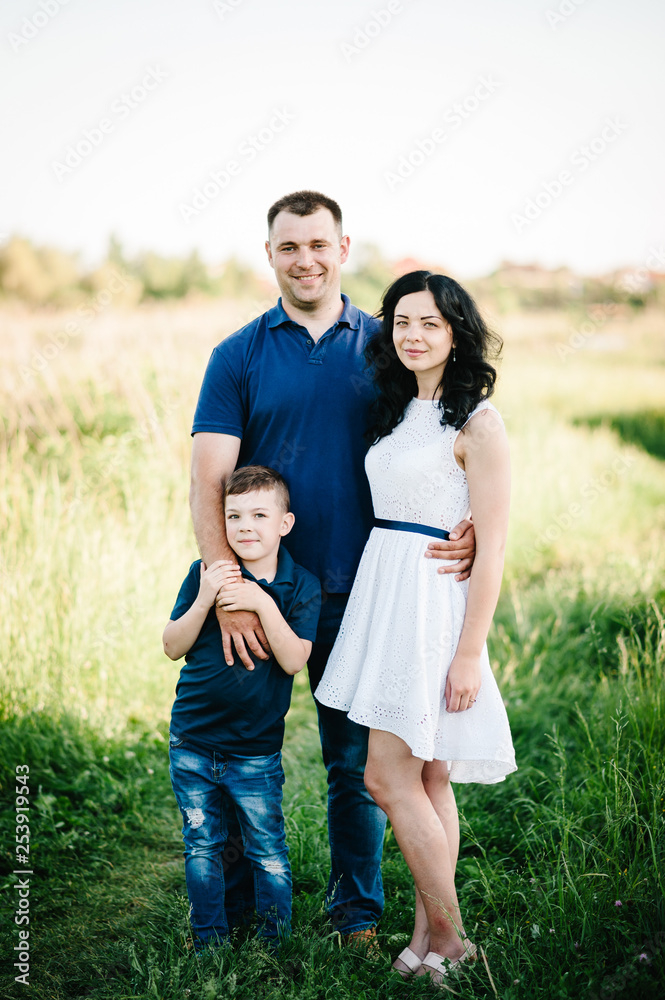 Happy young family spending time together outside in green nature on vacation outdoors. The concept of family holiday. Happy young family spending time together outside in green nature on vacation outdoors. The concept of family holiday.