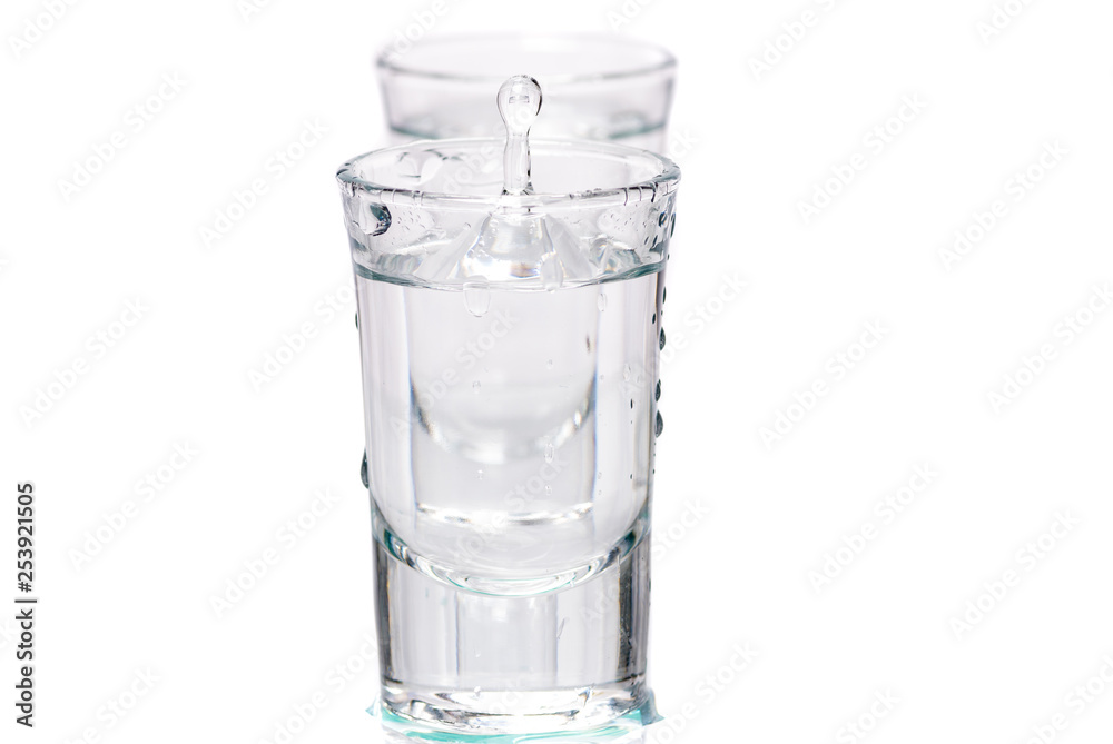 two glasses, shot glasses with liquid on a white background two glasses, shot glasses with liquid on a white background