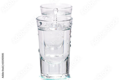 two glasses, shot glasses with liquid on a white background
