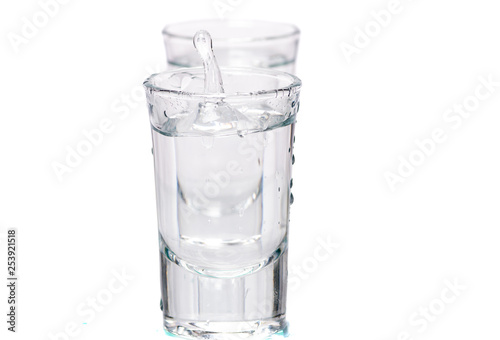 two glasses, shot glasses with liquid on a white background
