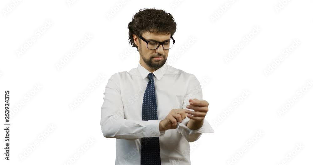 Caucasian man in glasses and tie standing on the white screen and rolling undrer the sleeves of white shirt. Caucasian man in glasses and tie standing on the white screen and rolling undrer the sleeves of white shirt.