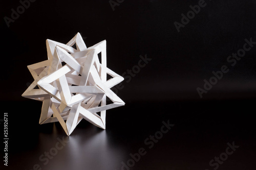 tetrahedron made of white paper on black background