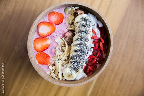 Berries smoothie bowl with strawberry and banana and godi ceed on wooden table. photo