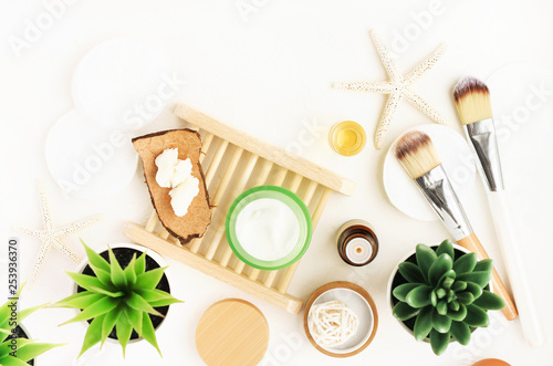 Healthy skincare facial treatment preparation, vegan beauty cosmetic products background. Facial moisturizer jar, green aloe plant, nourishing body butter. Spa at home, Top view white table. 