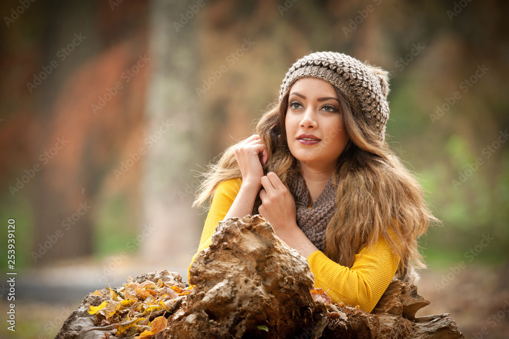 Obraz premium Happy Portrait fashion of a beautiful young Caucasian woman with a red cap and scarf and yellow pullover in autumn park,red green yellow threes. Autumn, season and people concept.Autumn lifestyle
