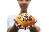 Women holding whole grain bun homemade with sesame and nut. Homemade bakery healthy food concept.