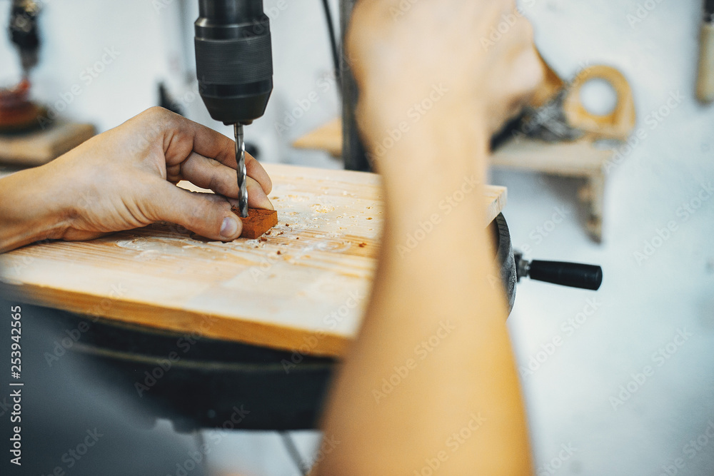 A man carves a tree. The carpenter works in a studio. An engineer provides a tree shape