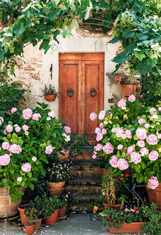 Fototapeta premium drzwi z kwiatem miasto Pienza, światowe dziedzictwo UNESCO, Europa, Włochy, Toskania