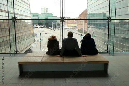 People looking outside windows inside a modern building.