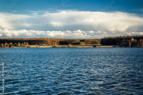 Pond with blue sky and small house, Czech landscape