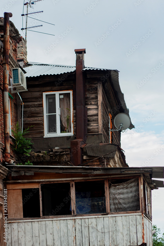 View of the old house with improvised extensions. Brick, wood, and satellite antennas. Russia, Rostov-on-Don, summer 2014. View of the old house with improvised extensions. Brick, wood, and satellite antennas. Russia, Rostov-on-Don, summer 2014.