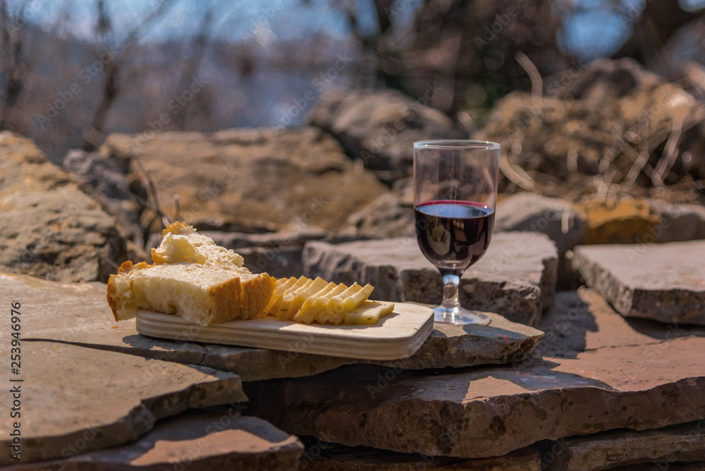rustic Lunch on the stone wall: homemade cheese, bread and wine. Mountain village.
