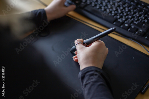 young woman designer using wacom stylus tablet for illustrating, retouching and animation photo