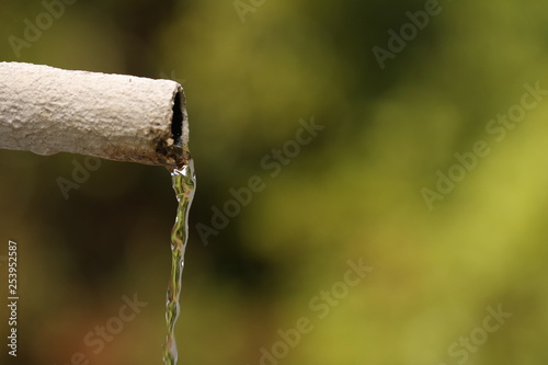 Saving precious rainwater in a severe drought, tank water pouring out of a pipe.