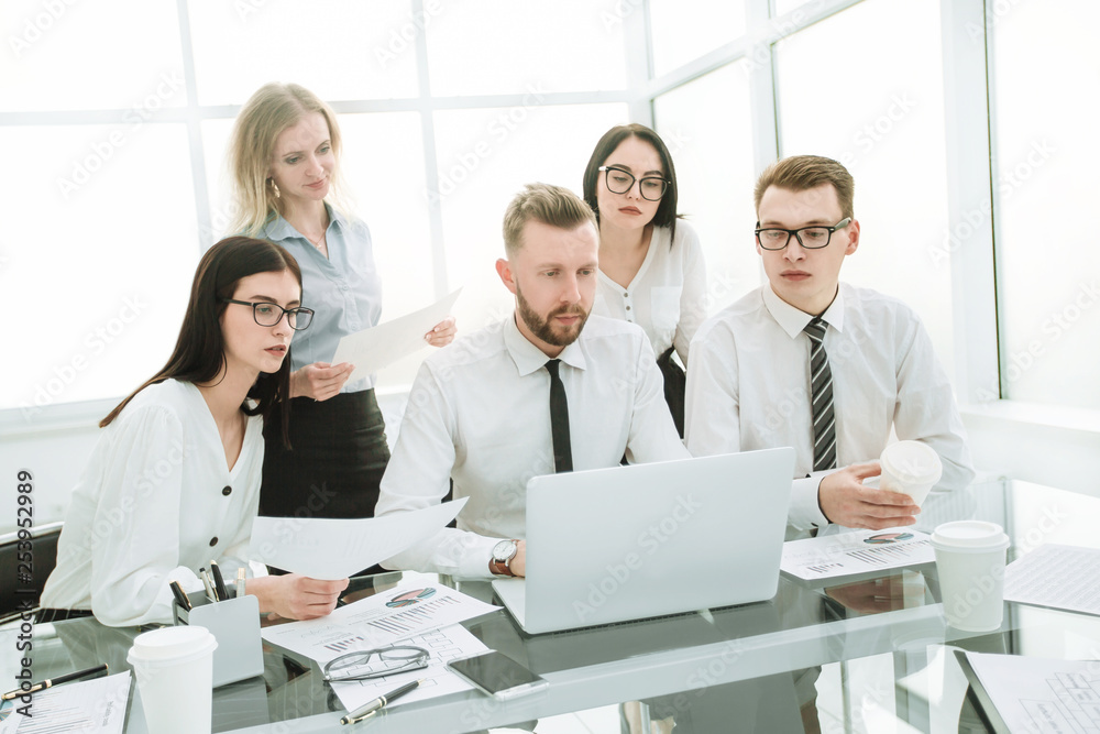 business people working and communicating while sitting at the office desk