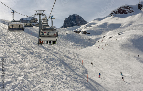 People skiing and going up the mountain by chairlift at Engelberg on the Swiss alps © fotoember