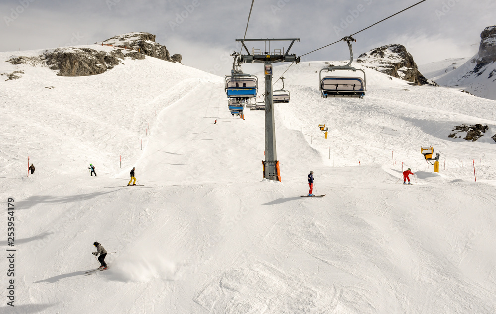 People skiing and going up the mountain by chairlift at Engelberg on the Swiss alps People skiing and going up the mountain by chairlift at Engelberg on the Swiss alps