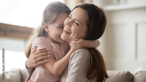 Loving young mother laughing embracing smiling cute funny kid girl