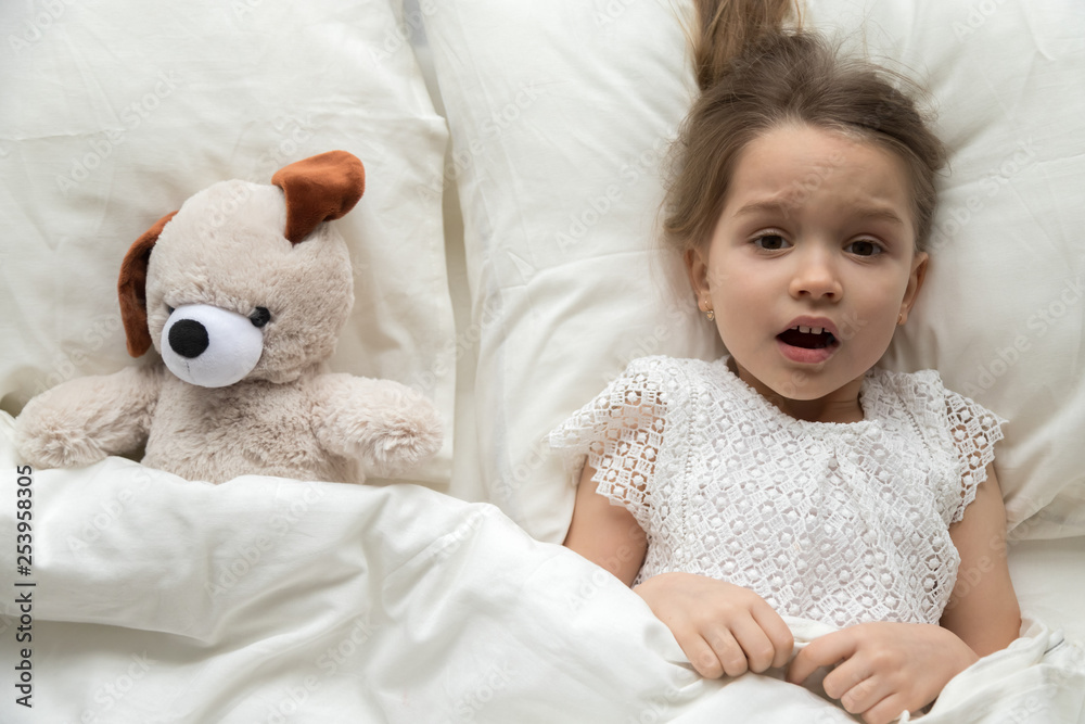 Scared child lying in bed with toy afraid of nightmare Scared child lying in bed with toy afraid of nightmare