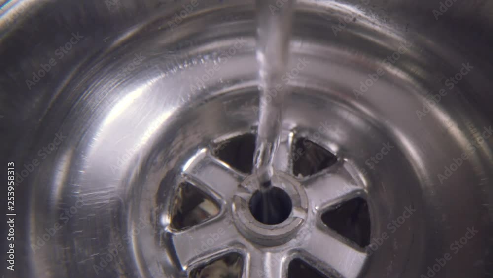 Water vortex shot underwater extreme macro close up of a laundry sink plug hole as water empties with a large vortex that forms above the lens. Lens focus shifts from drain hole to vortex. Water vortex shot underwater extreme macro close up of a laundry sink plug hole as water empties with a large vortex that forms above the lens. Lens focus shifts from drain hole to vortex.