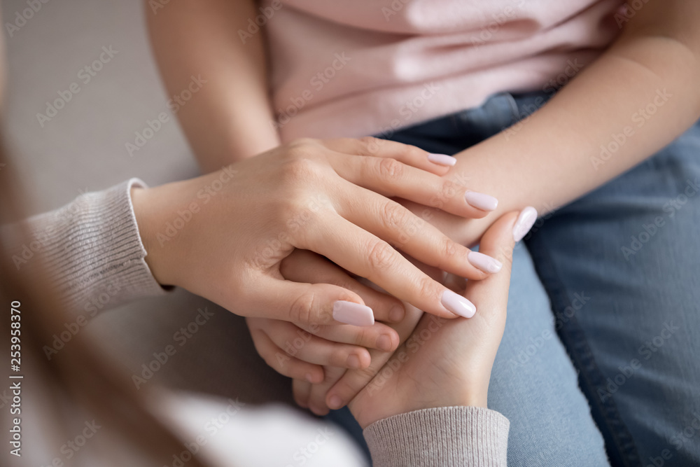 Adult woman mother holding hands of child, family trust, closeup Adult woman mother holding hands of child, family trust, closeup