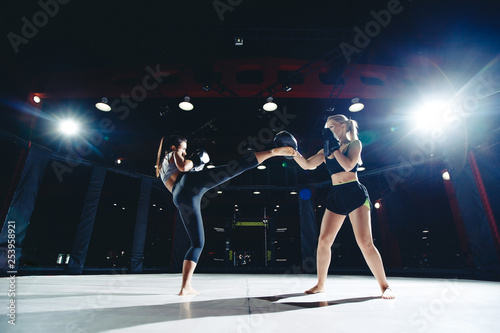 Training young women in ring mma octagon cage, kick and apercod hand