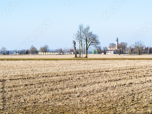 rural landscape with harvested fileld and village