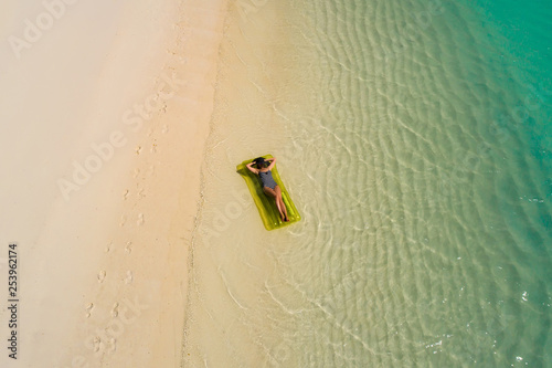 Aerial drone aerial view of Beautiful girl having fun on the sunny tropical beach. Seychelles