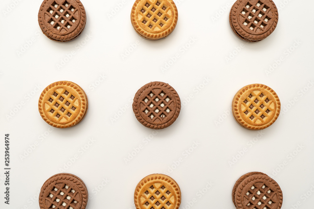 Close-up. Vanilla and chocolate cookies on a white background, chocolate one in the center. View from above Close-up. Vanilla and chocolate cookies on a white background, chocolate one in the center. View from above