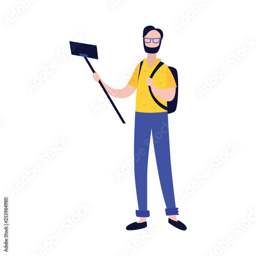 Young man with backpack making photo or video of himself with camera on mobile phone and selfie stick.