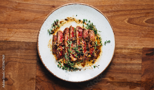 Obraz na plátne Sliced ribeye with garlic and thyme served on a plate