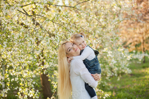 portrait of happy mother and daughter on nature in spring park
