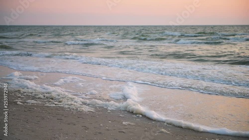 Red tide algae bloom toxic foam crashing with sunset reflection in Naples beach in Florida Gulf of Mexico on sand with nobody photo