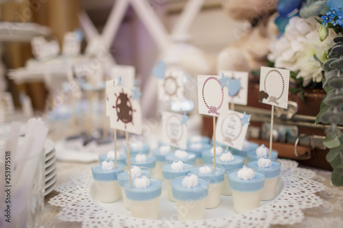 Foto blue and white christening candy bar: close up photo of pana cotta with sticks w