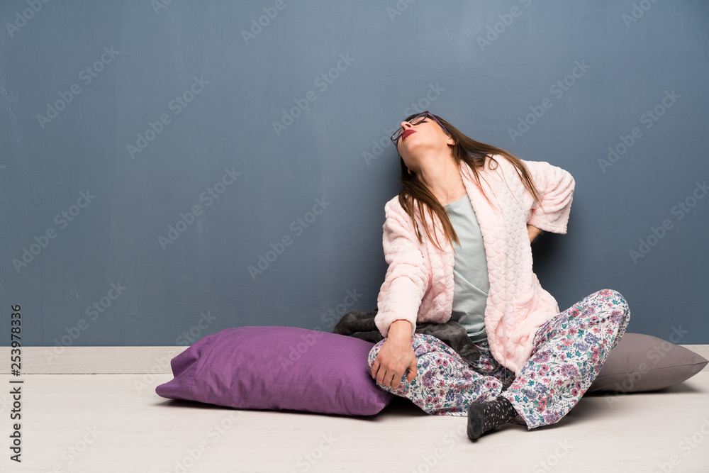 Woman in pajamas on the floor suffering from backache for having made an effort