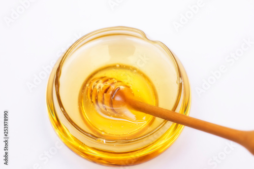 Honey pot and dipper isolated on white background, copy text