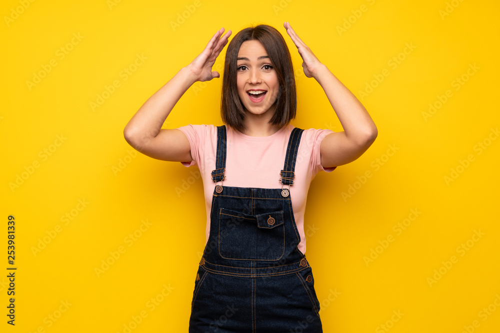 Young woman over yellow wall with surprise and shocked facial expression Young woman over yellow wall with surprise and shocked facial expression