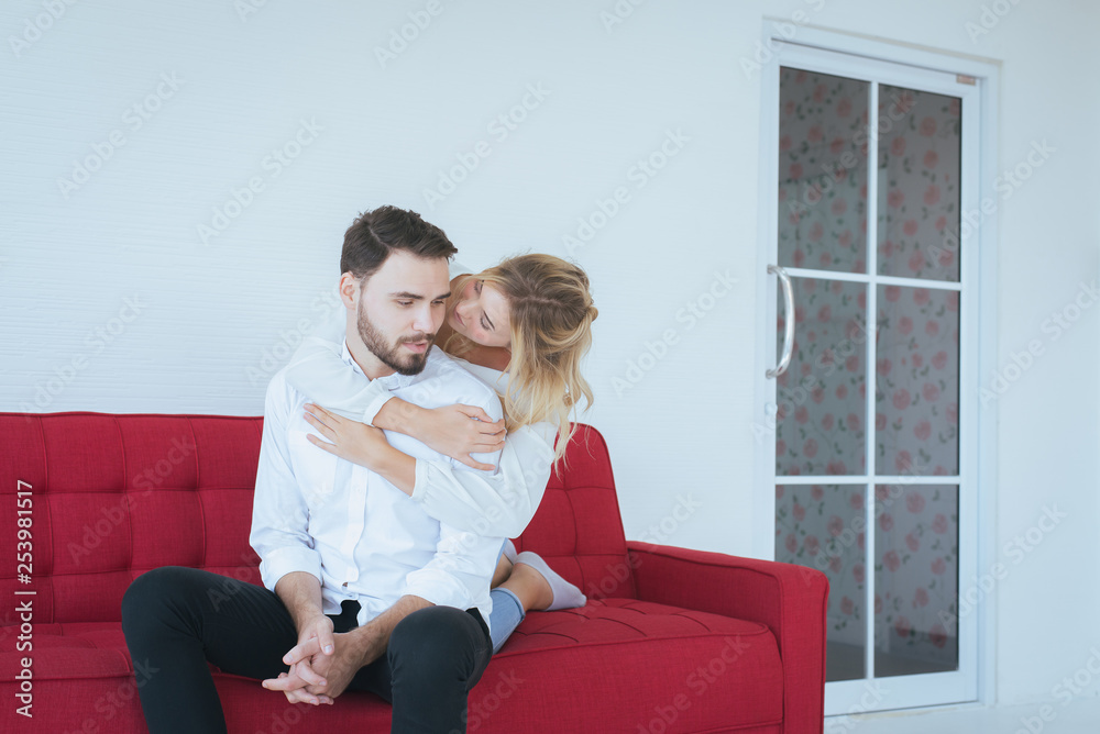 Obraz premium Couple in love girlfriend hugging her boyfriend on red sofa at home,Loving everything together,Happy and smiling