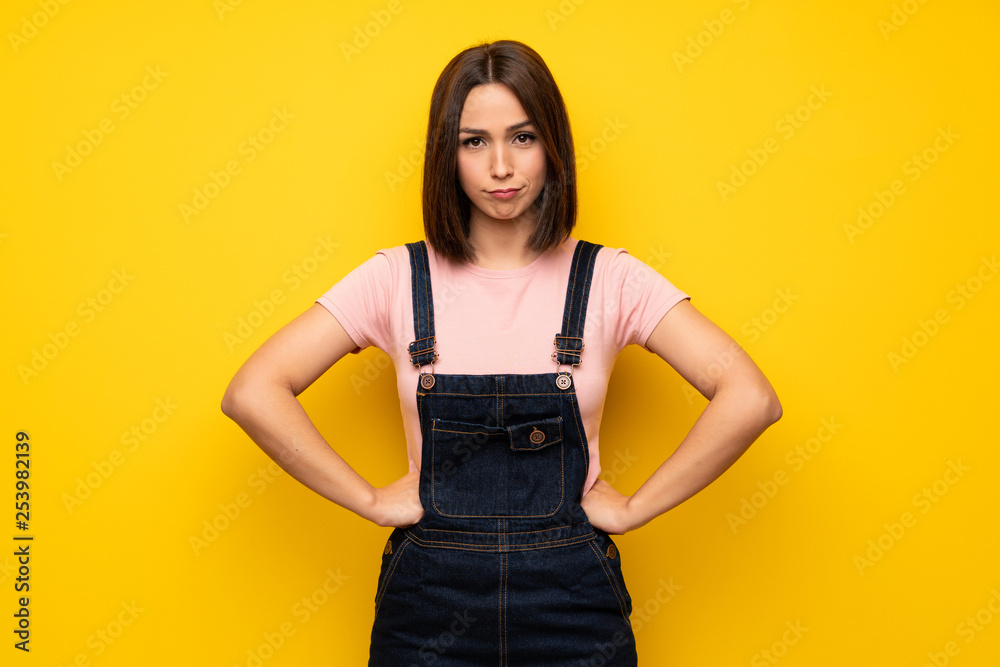 Young woman over yellow wall angry Young woman over yellow wall angry