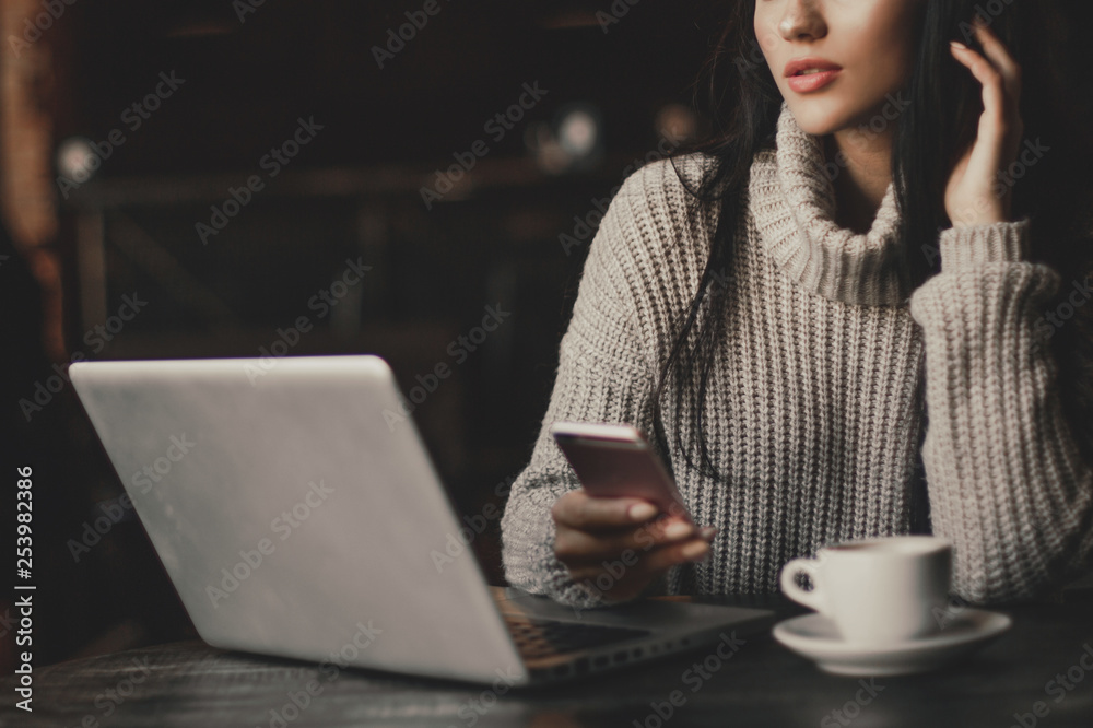 Business woman working on a laptop and drinking coffee in a cafe. Business woman working on a laptop and drinking coffee in a cafe.