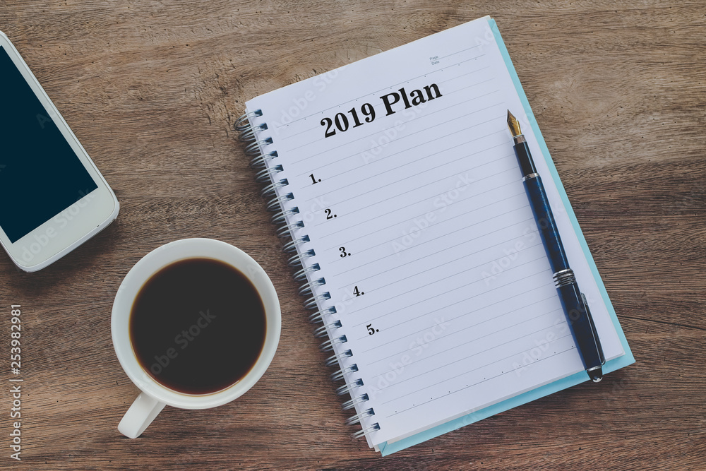 2019 Plan text on book note with cup of coffee, pen and smartphone. 2019 Plan text on book note with cup of coffee, pen and smartphone.