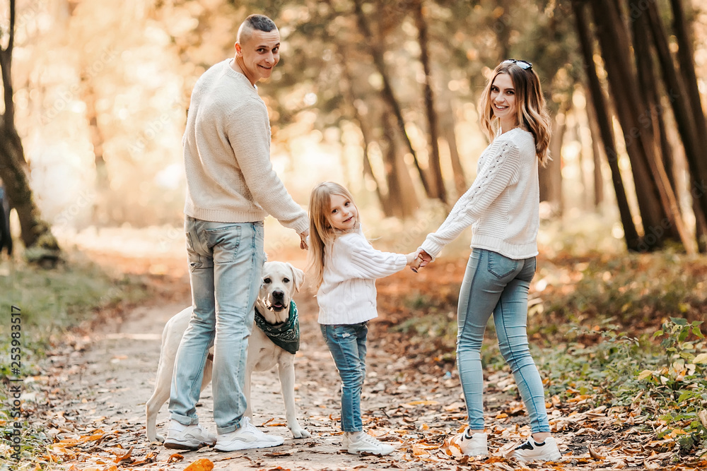 Happy beautiful family with dog labrador is having fun together walking the in park. Happy beautiful family with dog labrador is having fun together walking the in park.