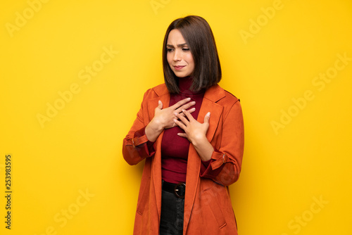 Young woman with coat having a pain in the heart