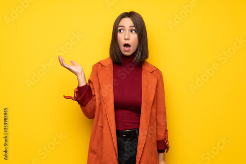 Young woman with coat surprised and shocked while looking right © luismolinero