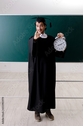 Graduate student in front of green board 