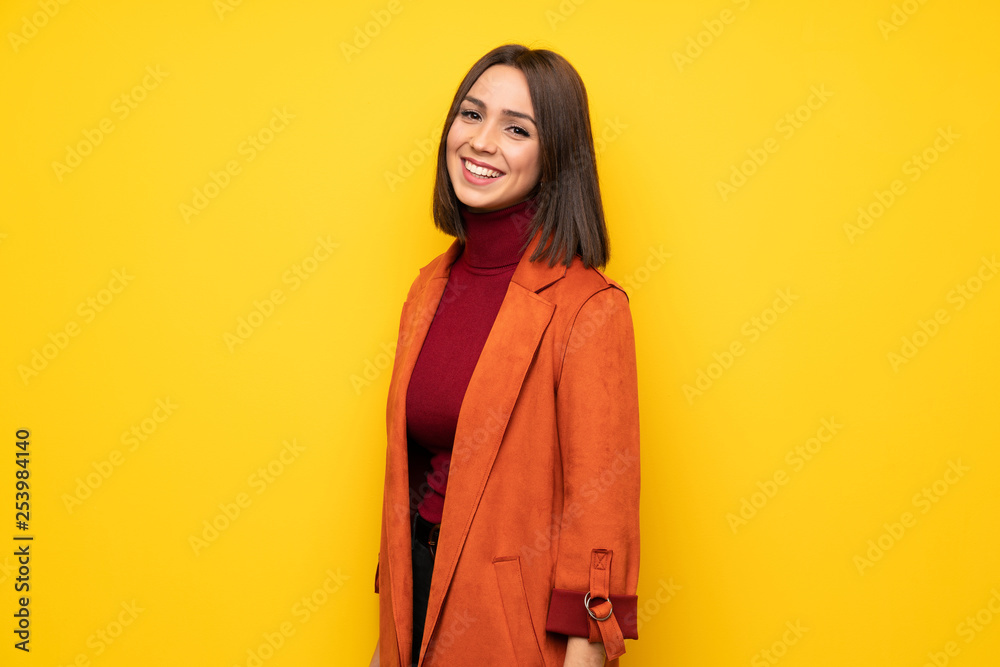 Young woman with coat smiling - obrazy, fototapety, plakaty 