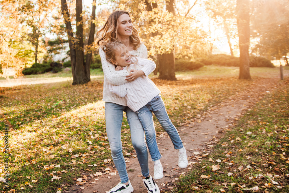 Happy daughter with mother is having fun walking in the park. Happy daughter with mother is having fun walking in the park.