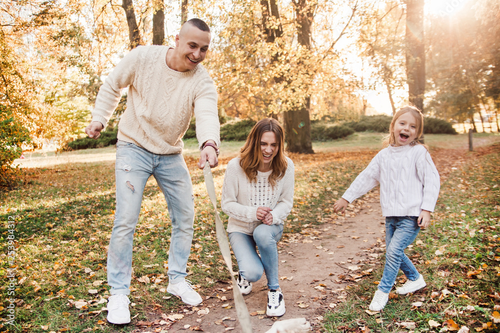 Fototapeta premium Happy family is having fun with dog labrador outdoors.