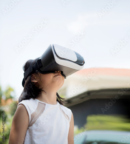 children wearing virtual reality glasses with fun and surprising face standing  outdoor