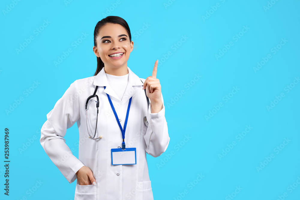 Portrait of bright young woman doctor with stethoscope over blue background pointing finger up. Portrait of bright young woman doctor with stethoscope over blue background pointing finger up.
